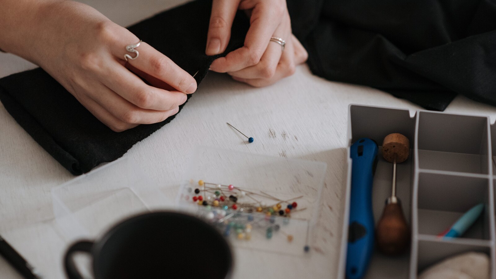 Seamstress hands pinning a wedding gown